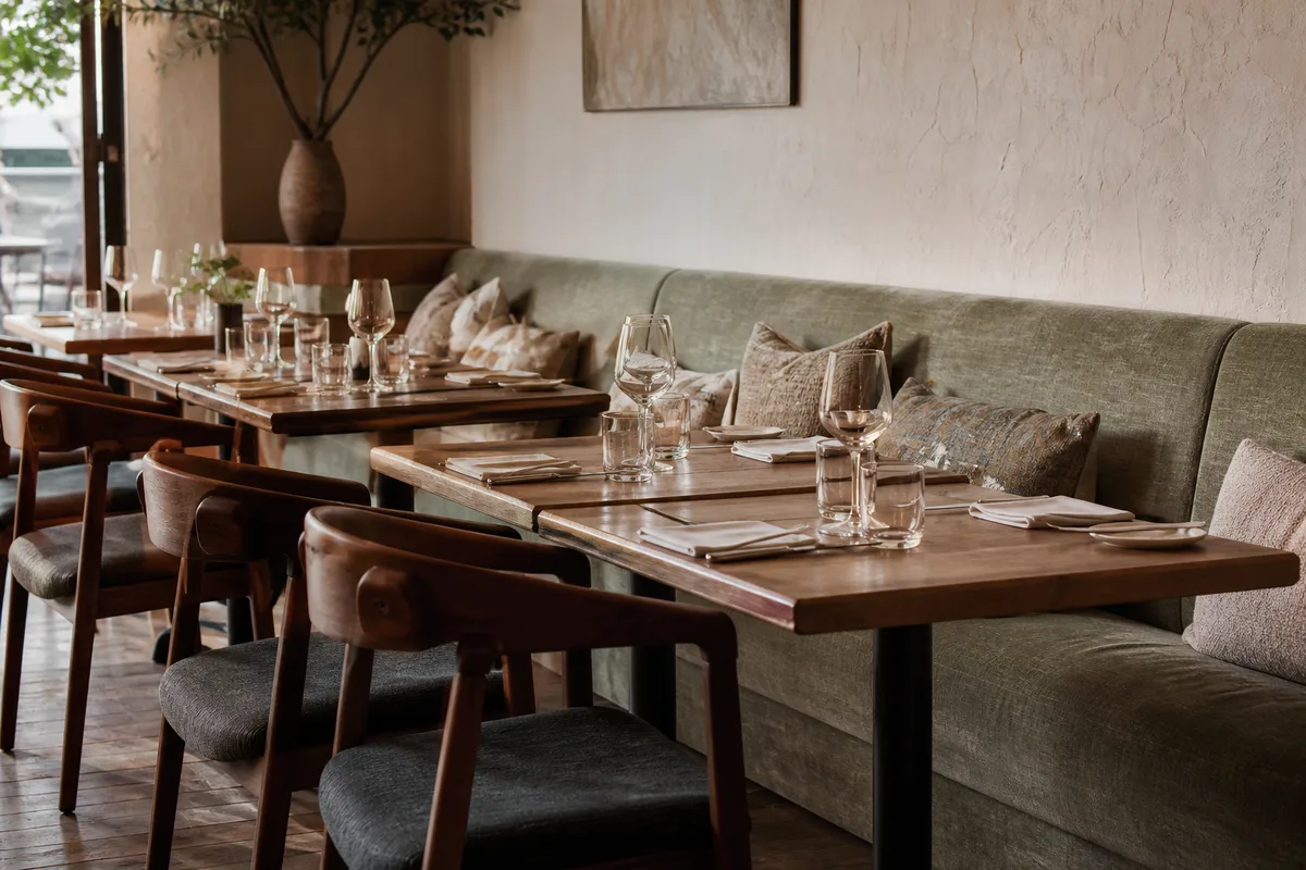 Banquette et tables dressées dans une salle de restaurant lumineuse