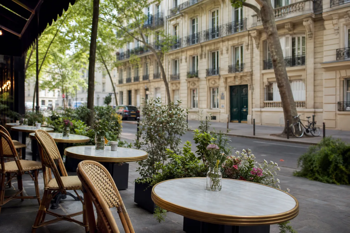 Terrasse de café parisien avec chaises en aluminium et tables rondes