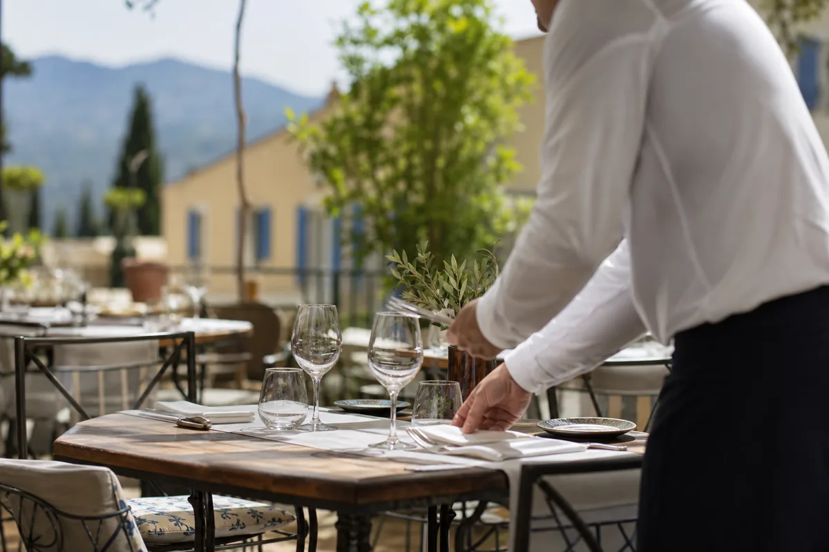 Serveur dressant une table dans un restaurant lumineux